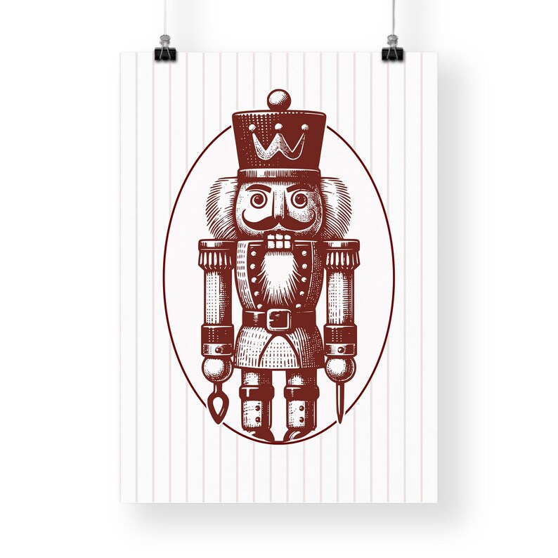 May include: A poster featuring a detailed illustration of a traditional nutcracker soldier in a maroon color. The nutcracker is inside an oval frame, set against a background of vertical pink stripes. The nutcracker has a crown, mustache, and a uniform.