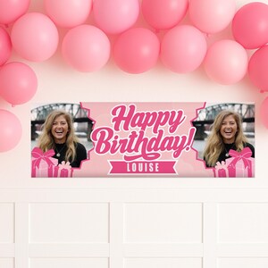 May include: A pink banner with the text "Happy Birthday!" and the name "Louise" in white script. The banner has photos of a smiling person and gift boxes. Pink balloons are above.