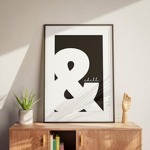 May include: Black and white typography print with a large ampersand symbol and the word "chill" in a cursive font.