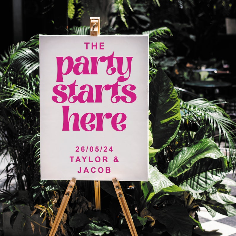 May include: White sign with pink text that reads "THE party starts here 26/05/24 TAYLOR & JACOB". The sign is on an easel in front of green plants.
