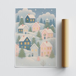 May include: A winter-themed art print featuring a village scene with blue and pink houses nestled in snowy hills. Evergreen trees and wreaths adorn the houses, with a starry sky backdrop. A rolled-up poster is visible on the right.