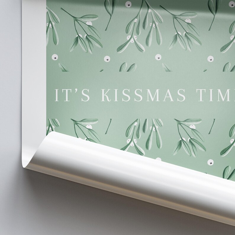 Puede incluir: Un papel de regalo verde y blanco con un patr&oacute;n repetitivo de ramas de mu&eacute;rdago y el texto "IT'S KISSMAS TIME".