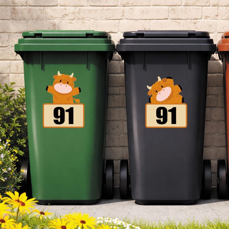 May include: Two trash bins, one green and one black, each with a sticker of a cartoon Highland cow and the number 91. The cow stickers are orange and brown with a pink face. The number 91 is in black on a beige background.