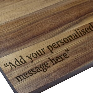Puede incluir: Una tabla de cortar de madera con el texto "A&ntilde;ade tu mensaje personalizado aqu&iacute;" grabado en la superficie.