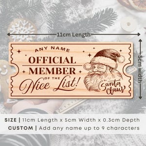 May include: A wooden Christmas ornament shaped like a ticket with the text "Official Member of the Nice List!" and a drawing of Santa Claus. The ornament is 11 cm long and 5 cm wide.