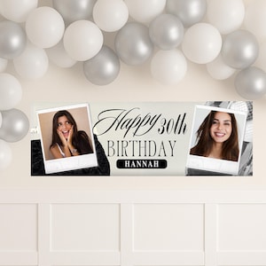 Op de afbeelding: Een cr&egrave;me banner met de tekst "Happy 30th Birthday Hannah" in zwart script, geflankeerd door twee foto's van een vrouw. De banner heeft zwarte accenten en is versierd met witte en zilveren ballonnen.