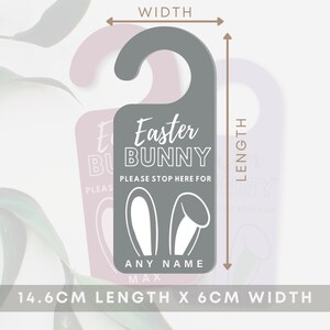 May include: A gray door hanger with a white bunny ear design and the text "Easter Bunny Please Stop Here For [Name]" in white. The door hanger measures 14.6 cm in length and 6 cm in width.