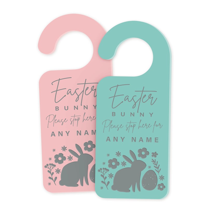 May include: Two Easter bunny door hangers, one pink and one teal. Each features a bunny silhouette, flowers, and the text "Easter Bunny Please stop here for [Name]"