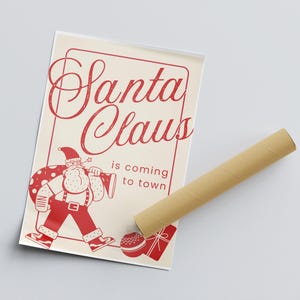 Puede incluir: Una ilustraci&oacute;n roja y blanca de Santa Claus llevando una bolsa de regalos. El texto dice "Santa Claus is coming to town".