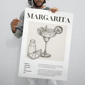 May include: A black and white illustration of a margarita cocktail recipe. The recipe includes tequila, lime juice, triple sec, salt, lime wedges, and ice. The text "MARGARITA" is at the top of the image.