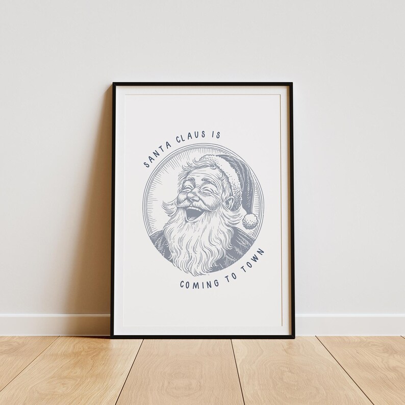 May include: A framed print with a blue and white illustration of Santa Claus with the text "Santa Claus is coming to town".