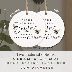 May include: Two white ceramic or MDF round ornaments with hemp string, each 7cm in diameter. The ornaments read "Thank you for Bee-ing such an amazing nurse" with bee illustrations.