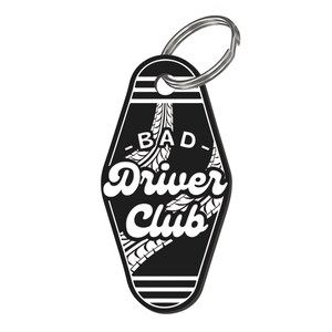 May include: Black and white motel key chain with the text "Bad Driver Club" and a tire tread design.