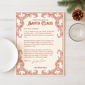 May include: A cream-colored letter from Santa Claus with red decorative borders and text. The letter is addressed to Alice & Hannah and includes a message about being on the Nice List. A pine cone, pine branch, and glass are in the background.