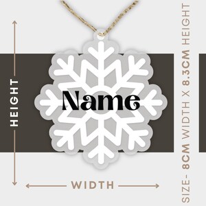 Op de afbeelding: Witte sneeuwvlok ornament met zwarte "Name" tekst in het midden. Het ornament is 8,3 cm hoog en 8 cm breed.