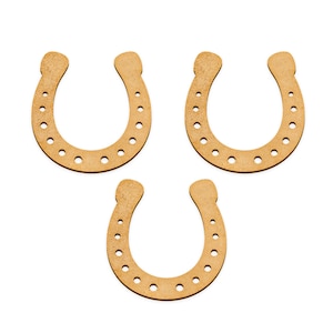 Op de afbeelding: Drie houten hoefijzers, elk met een bruine kleur en een reeks kleine gaatjes rond de randen.