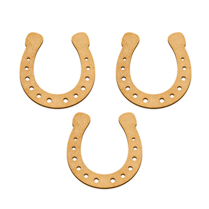 Op de afbeelding: Drie houten hoefijzers, elk met een bruine kleur en een reeks kleine gaatjes rond de randen.