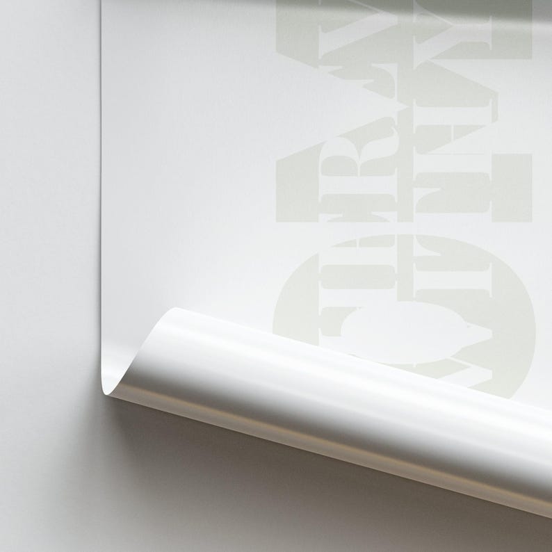 May include: A white sheet of paper with the word "GRAY" printed on it in a light gray color. The paper is rolled up at the bottom.