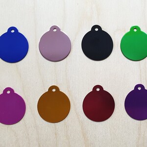 May include: Eight round metal tags with different colors. The tags are blank and have a hole at the top for attaching to a key chain or other item.