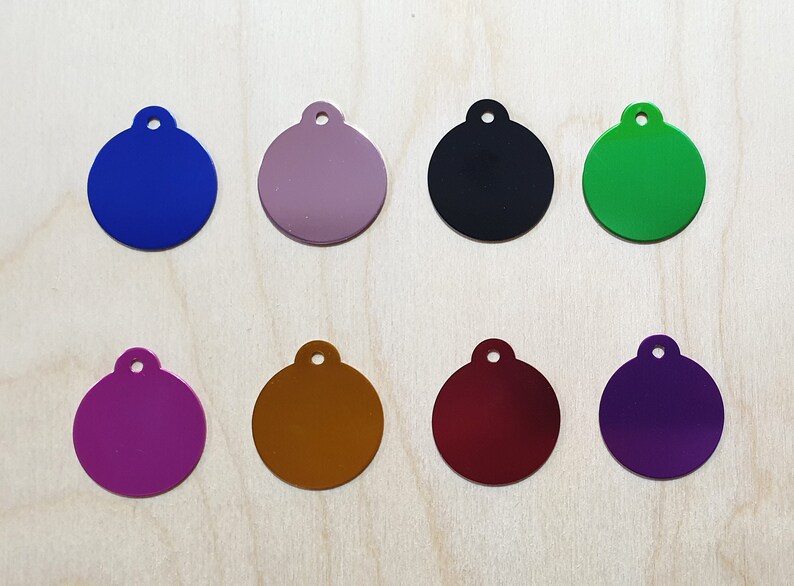 May include: Eight round metal tags with different colors. The tags are blank and have a hole at the top for attaching to a key chain or other item.