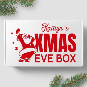 May include: White box with red text that says "Kaitlynn's Xmas Eve Box" and a red illustration of Santa Claus.