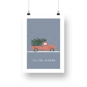 May include: A red pickup truck with a Christmas tree in the back driving through a snowy scene. The text 'Tis the season' is printed below the truck.