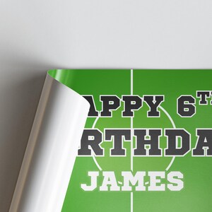 Puede incluir: Un p&oacute;ster verde con l&iacute;neas blancas que se asemejan a un campo deportivo. El texto "HAPPY 6TH BIRTHDAY JAMES" se muestra en blanco y negro, con el nombre en negrita. El p&oacute;ster est&aacute; parcialmente enrollado.