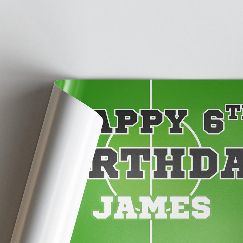 Puede incluir: Un p&oacute;ster verde con l&iacute;neas blancas que se asemejan a un campo deportivo. El texto "HAPPY 6TH BIRTHDAY JAMES" se muestra en blanco y negro, con el nombre en negrita. El p&oacute;ster est&aacute; parcialmente enrollado.