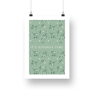 Puede incluir: Un p&oacute;ster imprimible verde y blanco con un patr&oacute;n repetitivo de ramitas de mu&eacute;rdago y el texto "IT'S KISSMAS TIME".