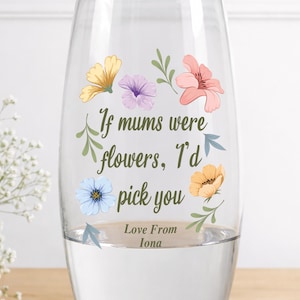 May include: Clear glass vase with colorful floral decals and the text "If mums were flowers, I'd pick you. Love From Iona.". The vase is filled with water and is a decorative item.