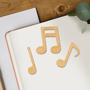 May include: Three wooden music note shapes on a white surface. The notes are in the shape of a treble clef, a crotchet, and a quaver.
