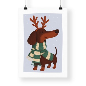 May include: Illustration of a dachshund wearing reindeer antlers and a green and white striped scarf. The dog is brown with a long snout and floppy ears. The background is a light blue with white snowflakes.