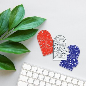 Puede incluir: Dos etiquetas en forma de coraz&oacute;n rojo y azul con un dise&ntilde;o de dados y llamas. El texto en las etiquetas dice "Tengo suerte de tenerte".