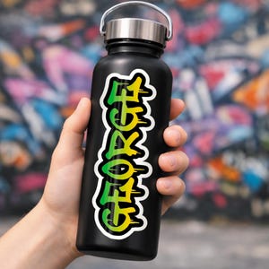 May include: Black water bottle with a silver lid, featuring a vibrant sticker with the name "GEORGE" in a graffiti-style font. The text transitions from green to yellow, outlined in white.