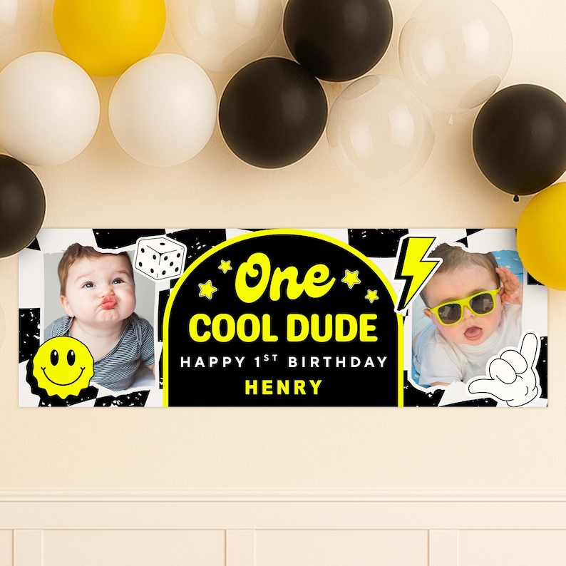 May include: A birthday banner with the text "One COOL DUDE Happy 1st Birthday HENRY" in yellow and white on a black background. The banner has two photos of a baby and is decorated with a smiley face, dice, and a lightning bolt. Balloons in yellow, white, and black are in the background.