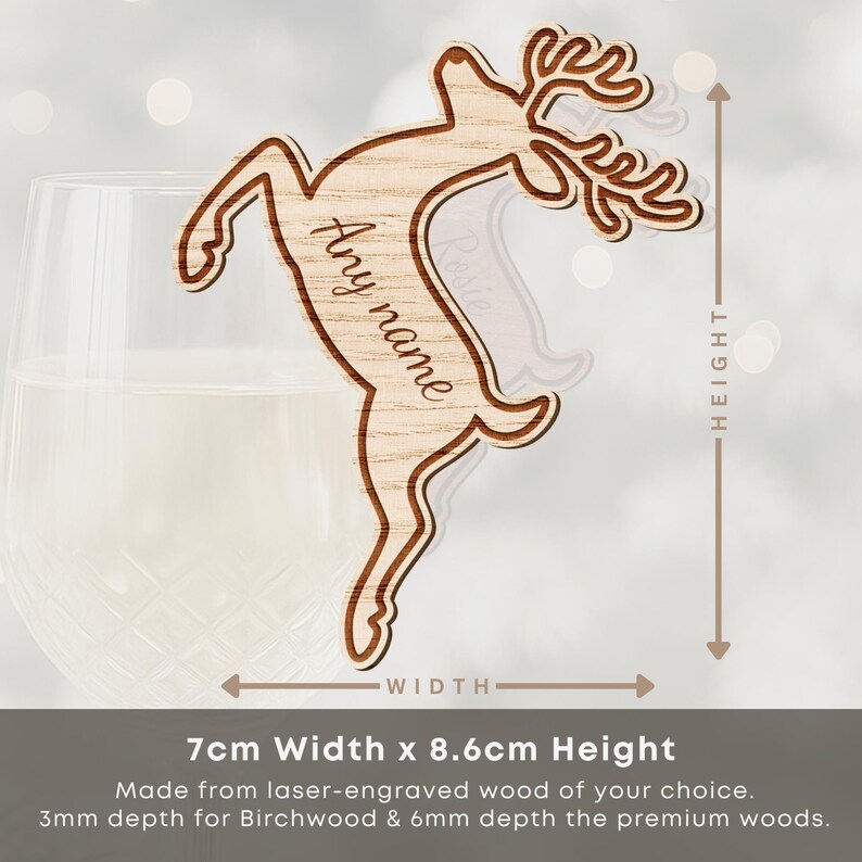 May include: A laser-engraved wooden reindeer ornament, 2.75 inches wide and 3.39 inches tall, with the text "Any name". The reindeer is light brown with a darker brown outline. The ornament is shown next to a glass of liquid.