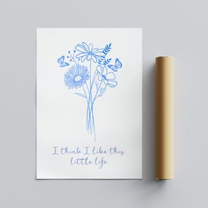 Puede incluir: Una tarjeta blanca con un dibujo de l&iacute;nea azul de un ramo de flores y mariposas. El texto "I think I like this little life" est&aacute; escrito en azul debajo de las flores.