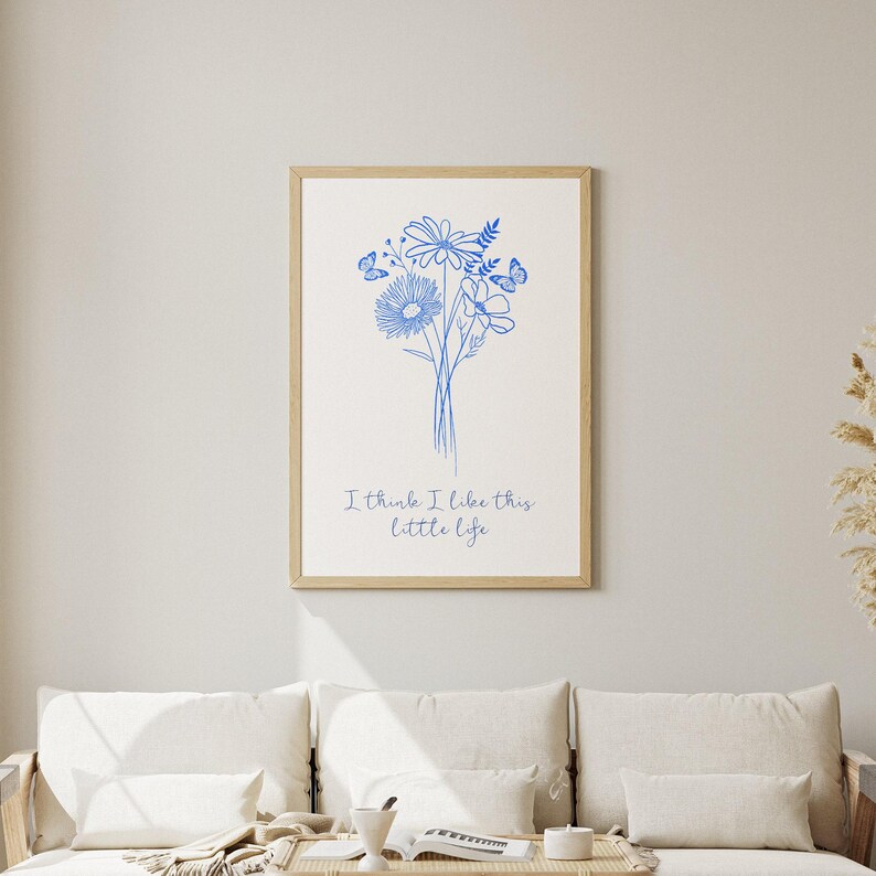 Puede incluir: Una impresi&oacute;n de arte imprimible blanca con un dibujo de l&iacute;nea azul de un ramo de flores y mariposas. El texto "I think I like this little life" est&aacute; debajo del dibujo.