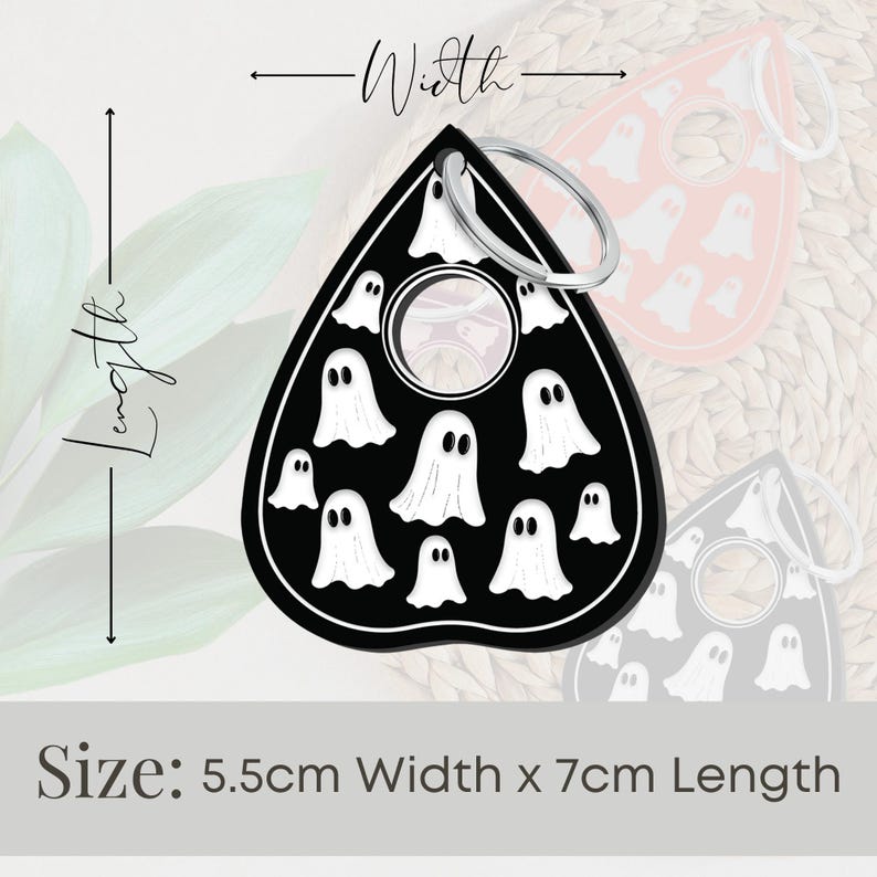May include: Black and white ghost-shaped keychain with a silver ring. The keychain is 5.5 cm wide and 7 cm long.  Size: 5.5cm Width x 7cm Length