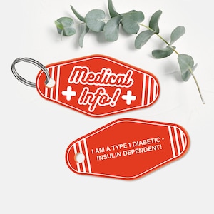 May include: Two red motel key tag style keychains with white text. The top keychain says "Medical + Info! +" and the bottom keychain says "I am a Type 1 Diabetic - Insulin Dependent!"