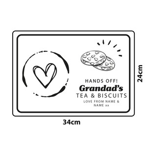 May include: A black and white sign with the text "HANDS OFF! Grandad's TEA & BISCUITS LOVE FROM NAME & NAME xx" and a drawing of two biscuits and a heart. The sign measures 34 cm by 24 cm.