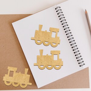 May include: Three brown wooden train engine cutouts on a white background. The train engines are different sizes and have a simple design.