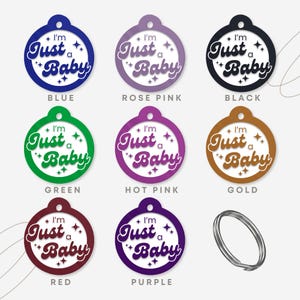 May include: Nine round, colorful, blank tags with the text "I'm Just a Baby" in a retro font. The tags are in blue, rose pink, black, green, hot pink, gold, red, purple, and white.