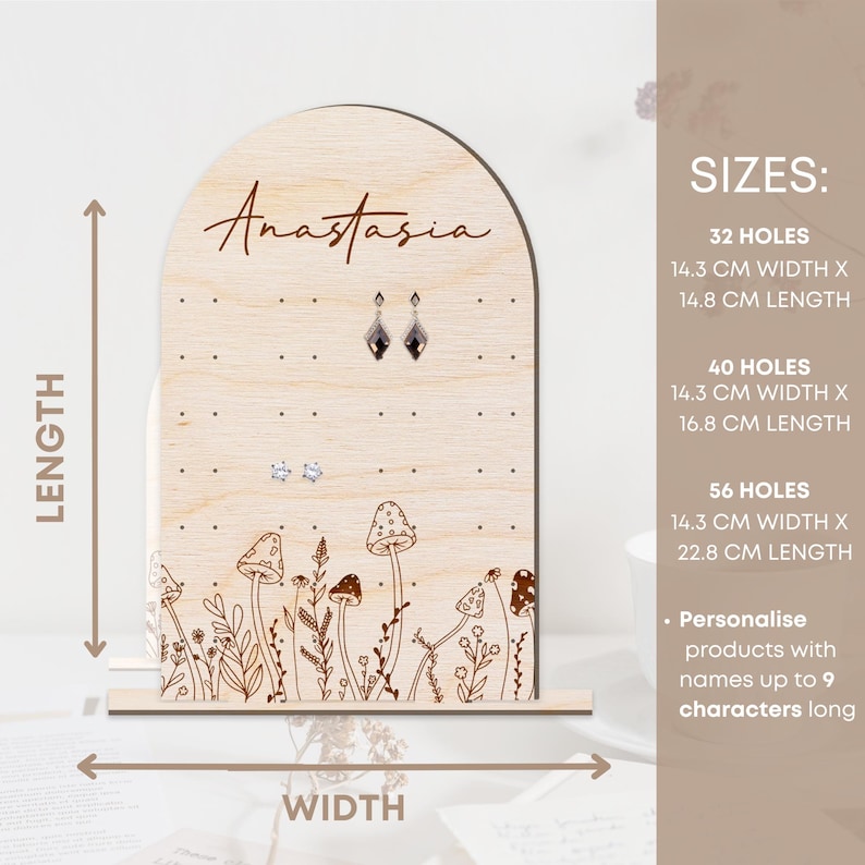 May include: Wooden earring display stand with a mushroom and floral design. The stand has 32 holes and is 14.3 inches wide by 14.8 inches long. It can be personalized with names up to 9 characters long.
