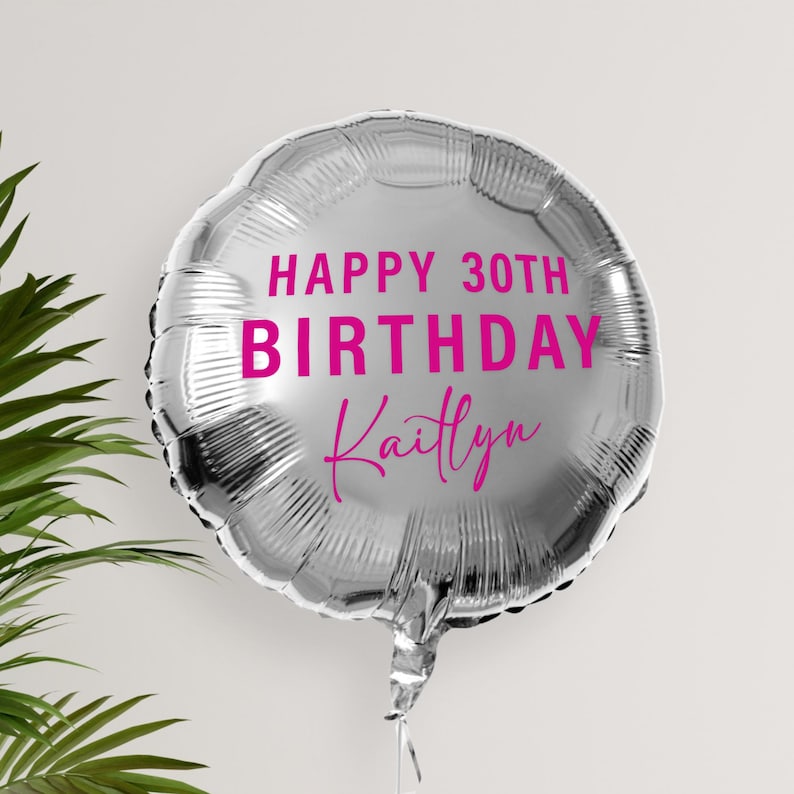 May include: Silver balloon with the text "Happy 30th Birthday Kaitlyn" in pink lettering.