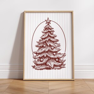 May include: A framed print featuring a detailed illustration of a Christmas tree. The tree is rendered in a deep red hue, adorned with ornaments and topped with a star. The background has vertical stripes.