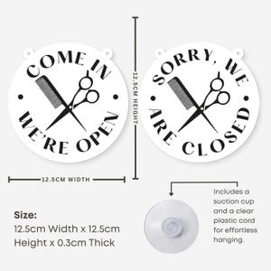 May include: White, round salon sign with black text and graphics. One sign reads "COME IN WE'RE OPEN" and the other reads "SORRY, WE ARE CLOSED". Each sign features a comb and scissors. The signs are 12.5cm wide and high.