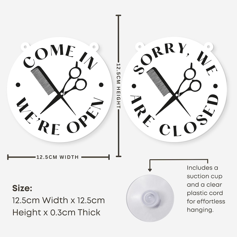 May include: White, round salon sign with black text and graphics. One sign reads "COME IN WE'RE OPEN" and the other reads "SORRY, WE ARE CLOSED". Each sign features a comb and scissors. The signs are 12.5cm wide and high.