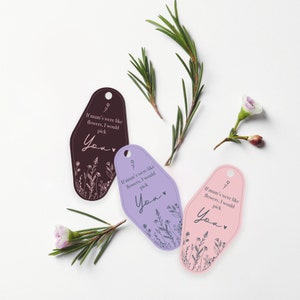 Puede incluir: Tres llaveros de estilo retro en marr&oacute;n, lavanda y rosa, cada uno con un dise&ntilde;o floral y el texto "If mum's were like flowers, I would pick You". Ramitas verdes y flores dispuestas alrededor de los llaveros.