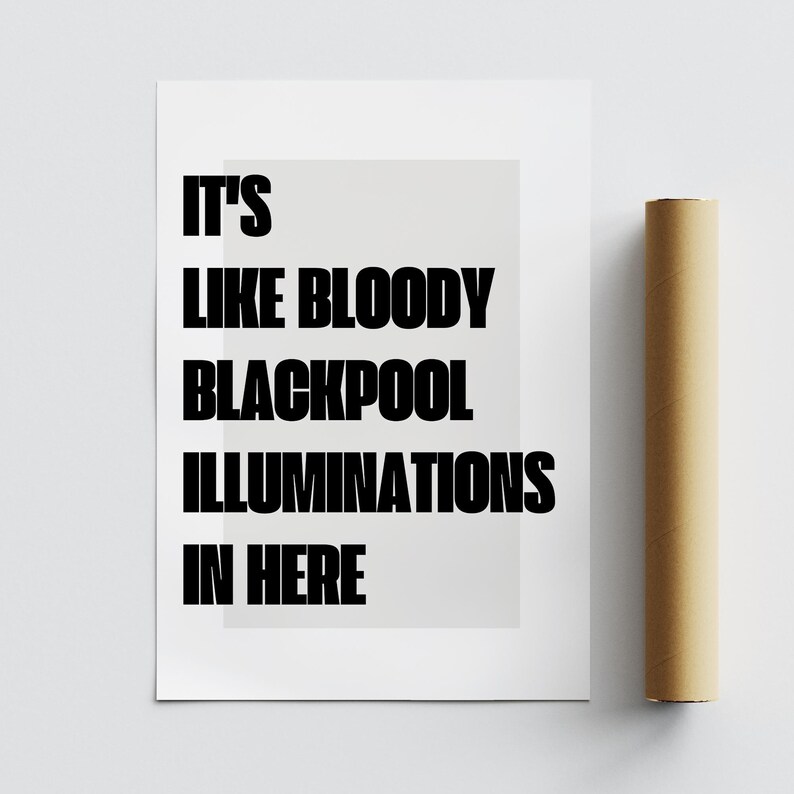 May include: A white poster with the text "IT'S LIKE BLOODY BLACKPOOL ILLUMINATIONS IN HERE" in bold black letters. A rolled-up brown paper is next to the poster.